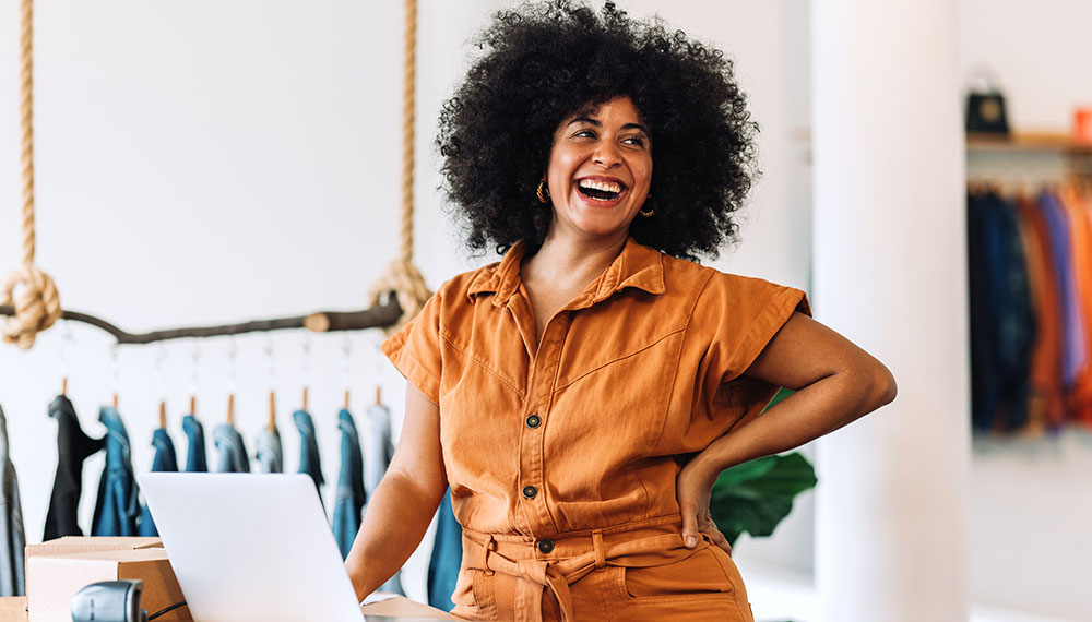 Black Business woman at clothing store with laptop
